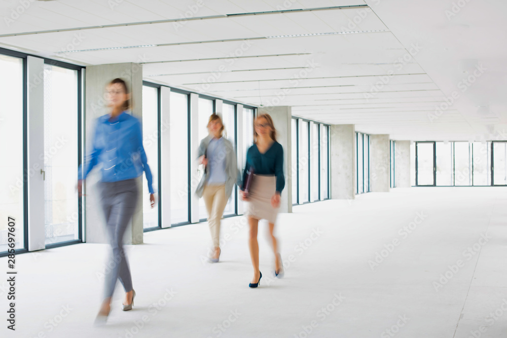 Business people walking in office corridor Business people walking in office corridor
