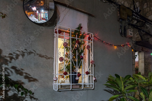 A Christmas tree decorated with toys is standing in the window in Haifa city, Israel