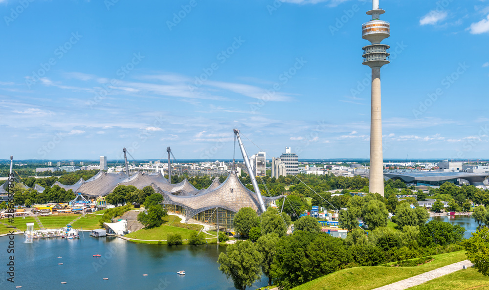 Munich Olympiapark in Germany. It is Olympic Park, landmark of Munich. Scenic view of former sport area from above. Cityscape of Munich with communication tower. Skyline of Munich city. - obrazy, fototapety, plakaty 