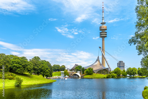 Munich Olympiapark in summer, Germany. It is Olympic Park, landmark of Munich. Scenic view of former sport district. Scenery of Munich with tower and lake. Beautiful landscape of Munich city. photo