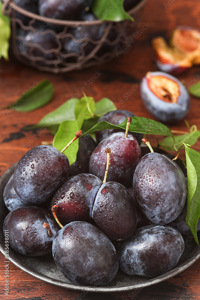 Fototapeta premium Plum fruits on rustic wooden background.