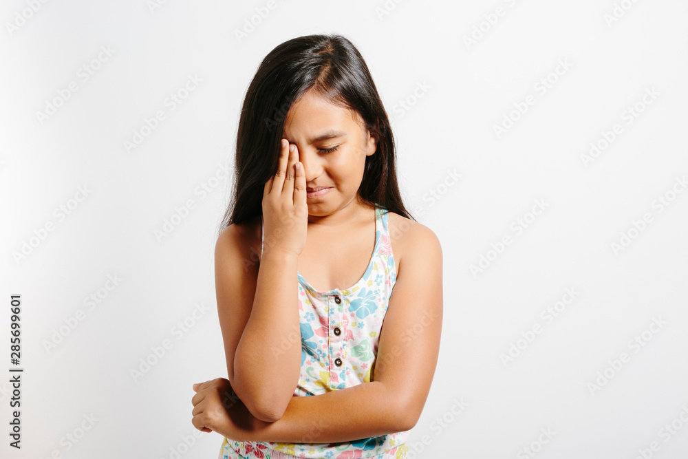 Fototapeta premium Young girl crying over white background.