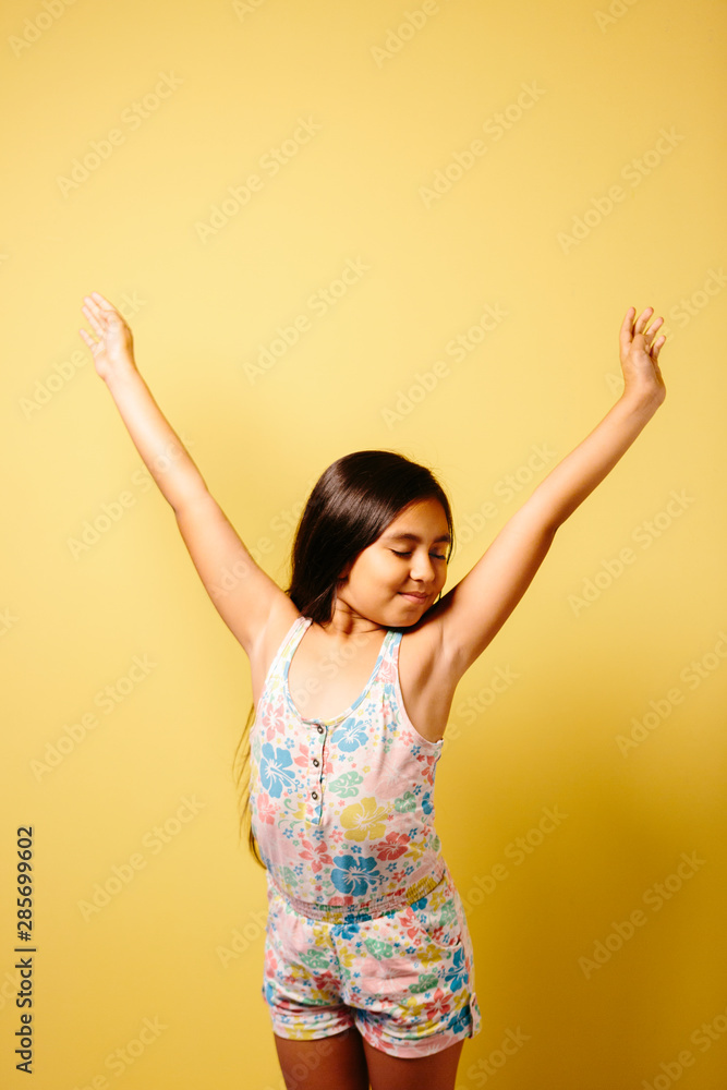 Young girl stretching over yellow background Young girl stretching over yellow background