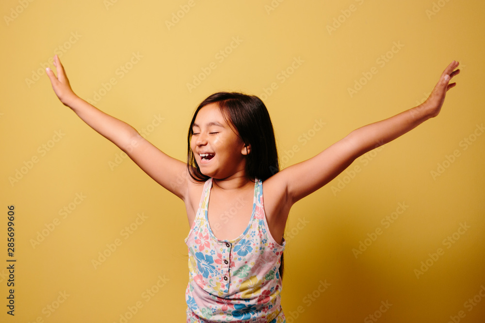 Young girl laughing over yellow background Young girl laughing over yellow background