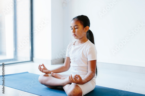 Young girl doing yoga over white background