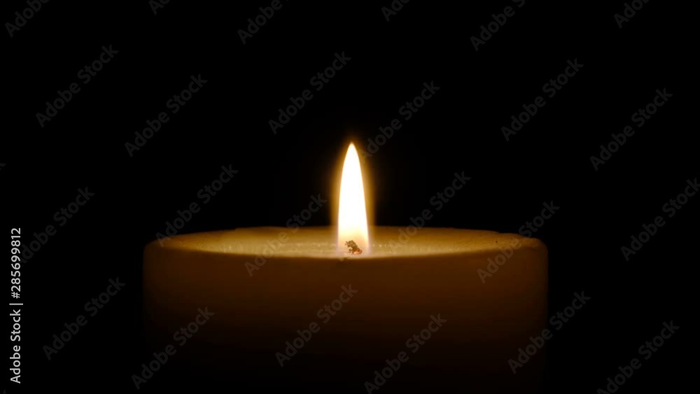 A large thick candle is lit with a match, then it is extinguished by the wind, a close-up shot on a black background A large thick candle is lit with a match, then it is extinguished by the wind, a close-up shot on a black background