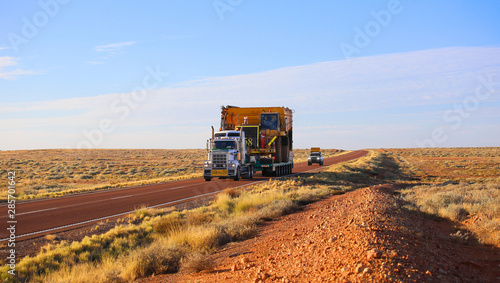 Truck oversize rides on road. Large truck driven mining dumper. Oversized blocked all way. "Oversize" wide load