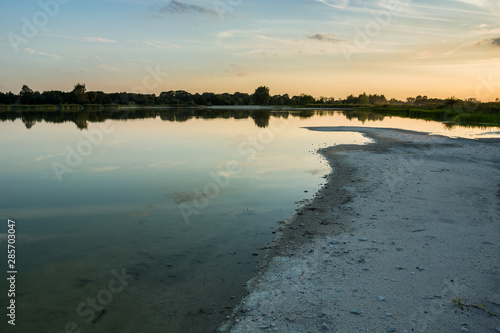 Shore and beach of a calm lake  evening view