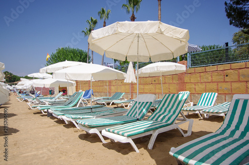 Beach loungers and umbrellas at the sunny beach in Turkey