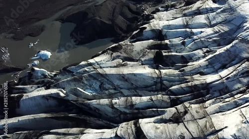 Aerial, drone shot, over the Sollheimajokull Glacier, at the Jokulhlaups glacial lagoon, near Myrdalsjokull, on a sunny day, in southern Iceland photo