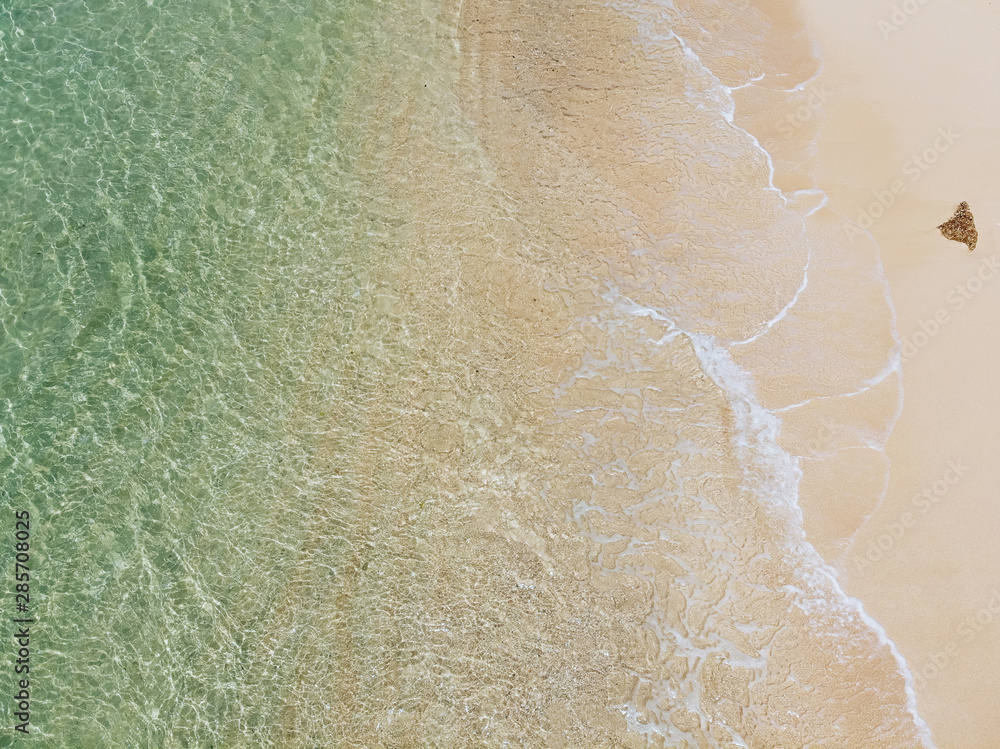 Fototapeta premium beautiful sandy beach with turquoise water and soft blue foaming ocean wave. Tropical background and travel concept