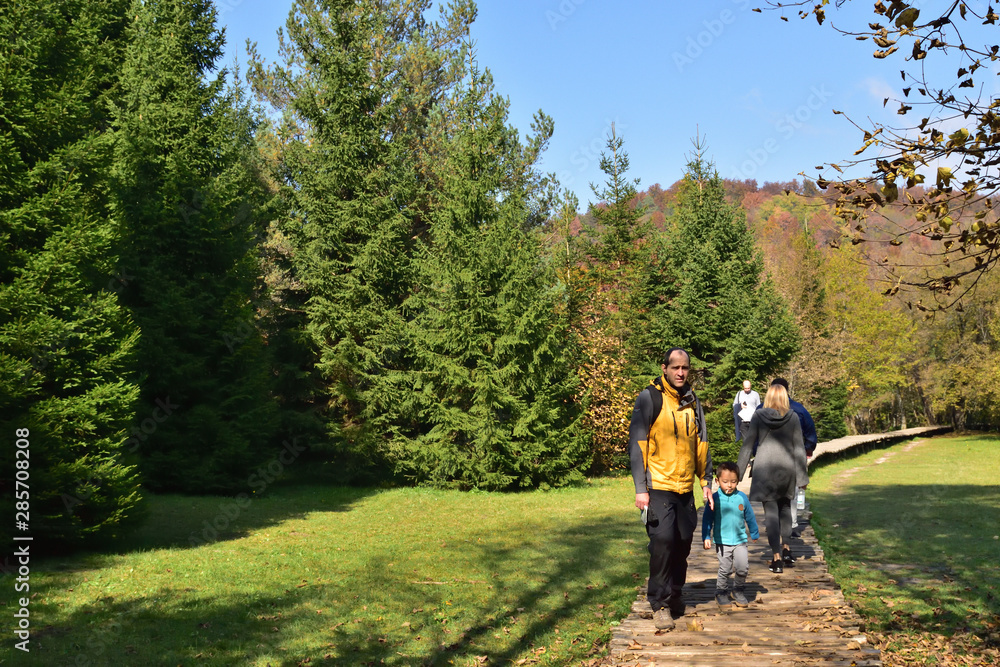 Boy and his father traveling together, hiking in Plitvice National Park, Croatia, in the fall Boy and his father traveling together, hiking in Plitvice National Park, Croatia, in the fall