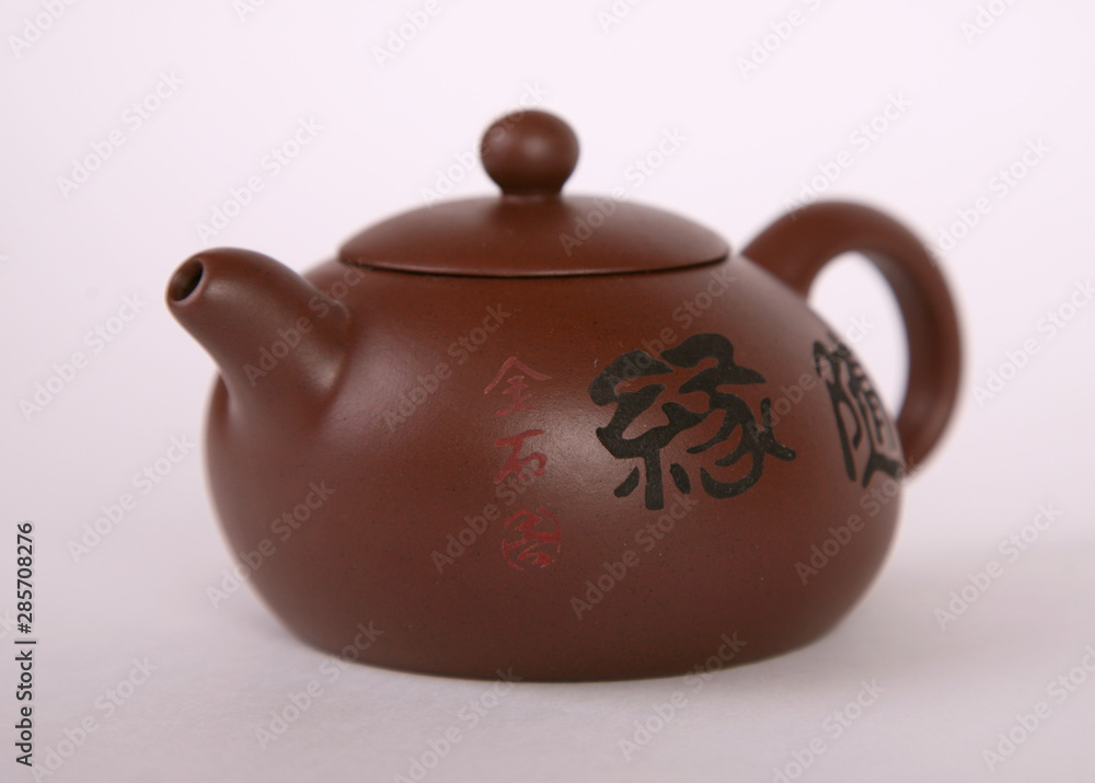 brown old isolated clay teapot on white background with hieroglyphs brown old isolated clay teapot on white background with hieroglyphs