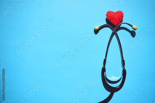 Medical stethoscope head and red heart on blue background. heart disease, rate measure, Cardio therapeutist, arrhythmia concept photo