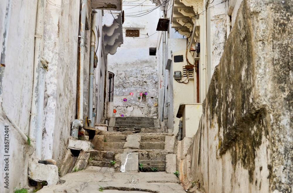 Narrow street with old white houses, in Udaipur, India