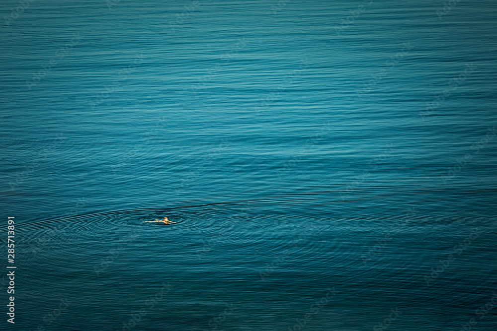High angle view of a swiming person in the sea High angle view of a swiming person in the sea
