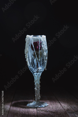 Glass decorated with streaks of wax with a small dry rose inside. Stylized drinks for Halloween