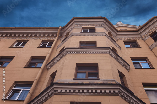 architecture. the wall of the old house against the blue sky. background with part of the building in the style of Stalin's empire.