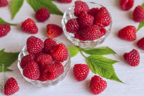 raspberry on the table. raspberries in glass bowls and on a white background close-up. fresh raspberry closeup.