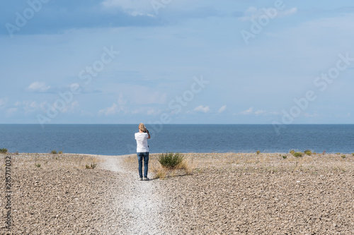 Tourist in an open coastal landscape with pebbles photo