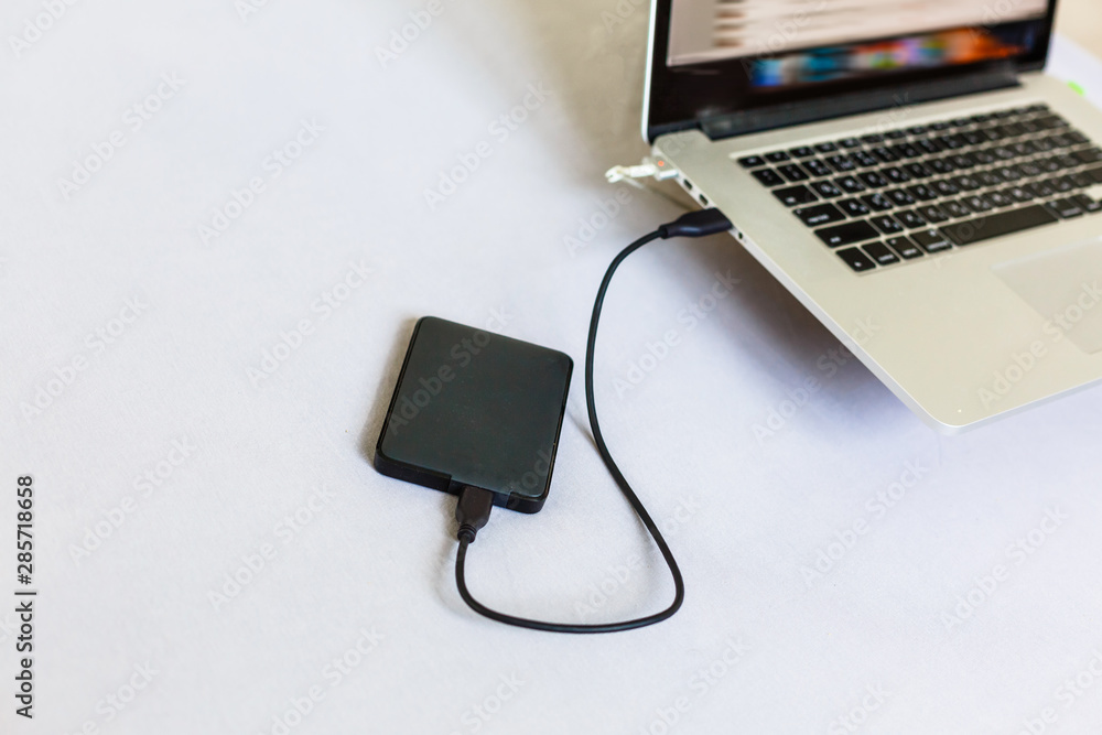 Black external hard disk connecting to a laptop Stock Photo Adobe Stock