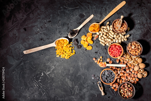 Mix of nuts and dried fruits on dark background. Healthy food and snack