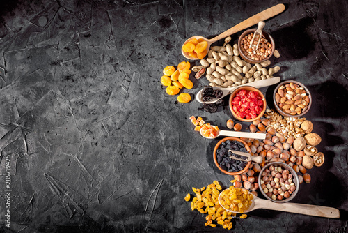 Mix of nuts and dried fruits on dark background. Healthy food and snack. Top view whith copy space