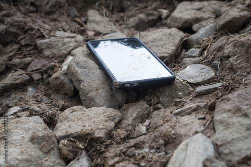 Smartphone among stones and dirt