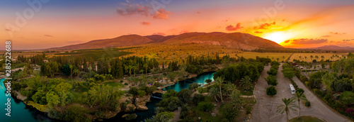 Photography Aerial view of the sunset over Sachne or Gan Hashlosha oasis, with popular water