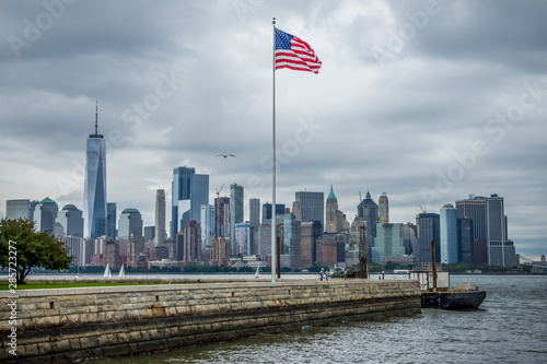 New York Manhattan skyline from liberty island with American flag