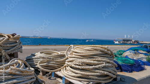 Wallpaper Mural View on the fishing gear and equipment on the port. Lay out various fishing nets, hawser, mooring line, ropes. Preparing to sail. Fishing at the sea. Drying and repairing nets on the dock.	 Torontodigital.ca