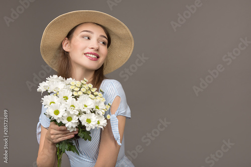 happy young woman smiling. Hold white flowers in hands. Enjoying a gift