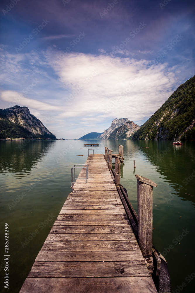 Wooden pier with Austrian mountains in the background.