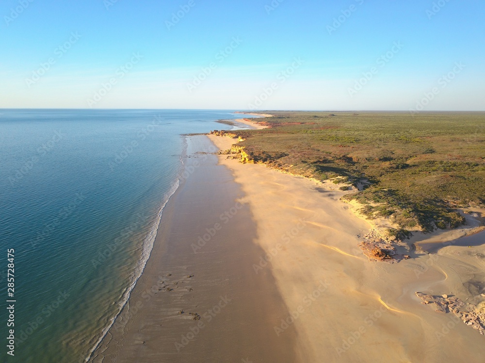 Scenic panoramic view of remote coast near Broome, Western Australia, with  ocean beach, cliffs, outback landscape, sunny blue sky and horizon as copy space.