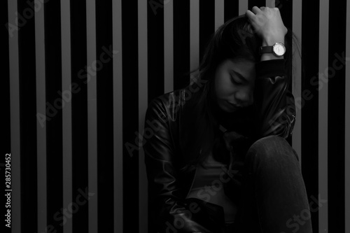 Portrait of asian girl are sitting on the floor beside the wall and looked sad. Black and white images of Thai women are suffering from depression.