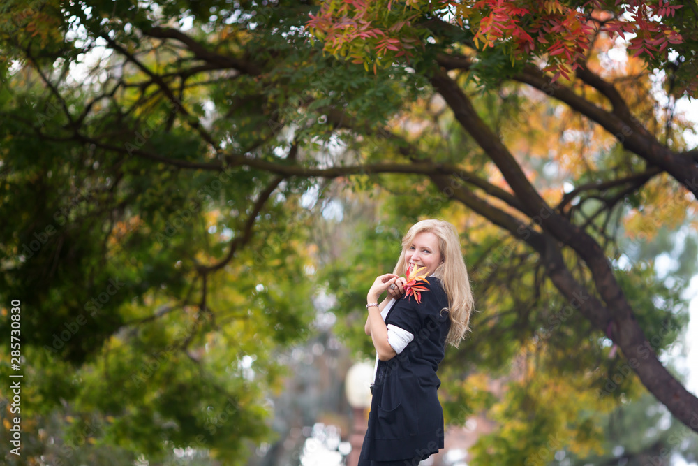 Portrait of Caucasian blond woman fall colors tree on background