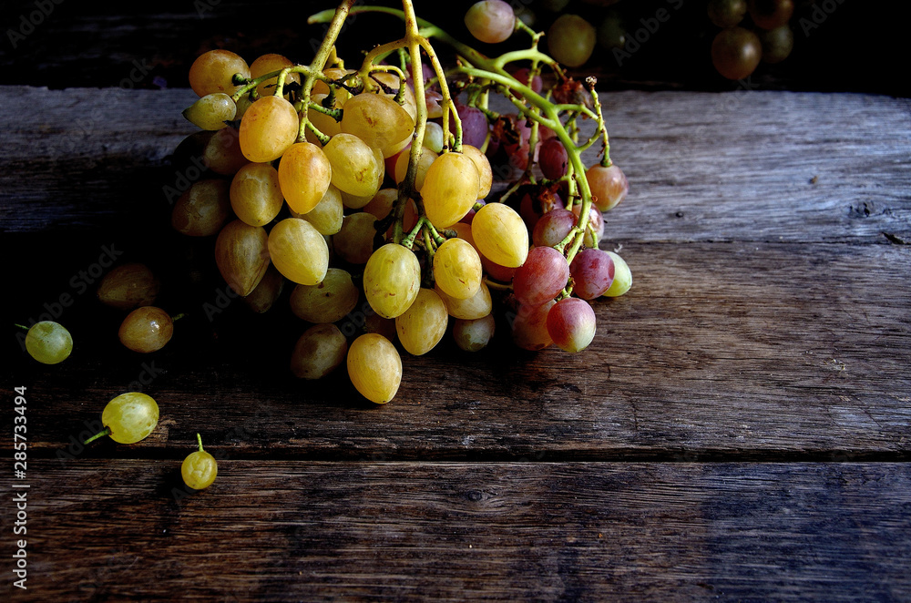 A bunch of grapes lying on old wooden boards. A bunch of grapes lying on old wooden boards.
