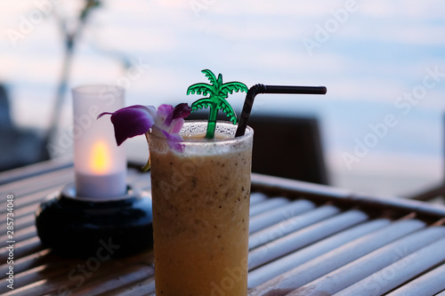 Wallpaper Mural Passion fruit juice closeup placed on a wooden table, twilight sea background,, intimate atmosphere in Thailand Torontodigital.ca