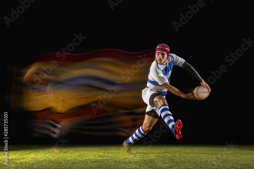 New star of the competitive. One caucasian man playing rugby on the stadium in mixed light. Fit young male player in motion or action during sport game. Concept of movement, sport, healthy lifestyle. © master1305