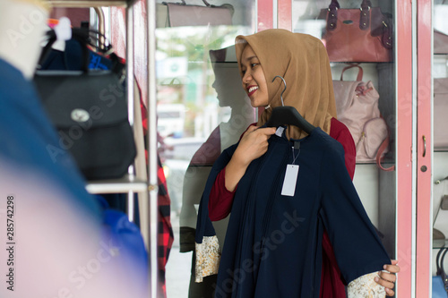 portrait of an attractive young asian muslim woman shopping in a fashion strore