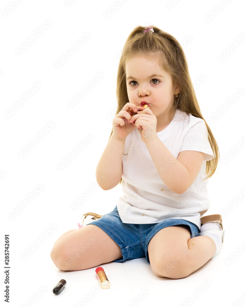 Little girl paints lips with mom's lipstick. Little girl paints lips with mom's lipstick.
