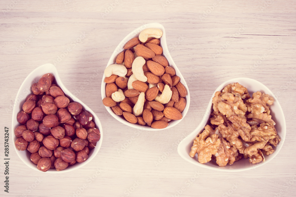 Different nuts and almonds containing vitamin, minerals and acids, nutritious eating concept Different nuts and almonds containing vitamin, minerals and acids, nutritious eating concept