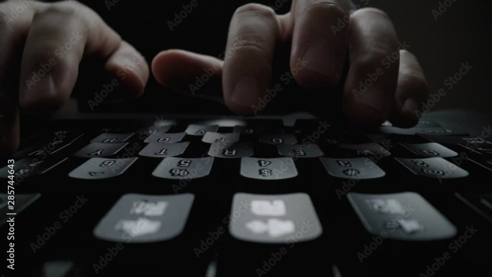 Close-up man typing on computer keyboard with hands and fingers. Macro soft focus dolly shot. Computer programming, text chat online messaging and online marketing business concept.