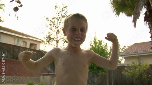 A boy poses like a bodybuilder.