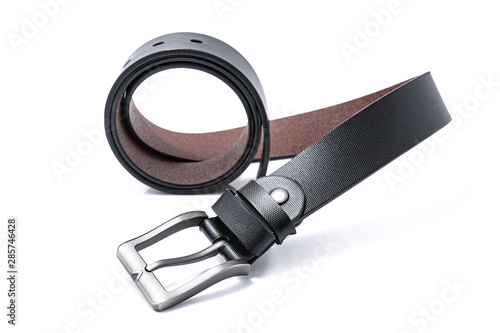 Black men's leather belts men's elegance trend on round shape with a white background. Fashion concept.