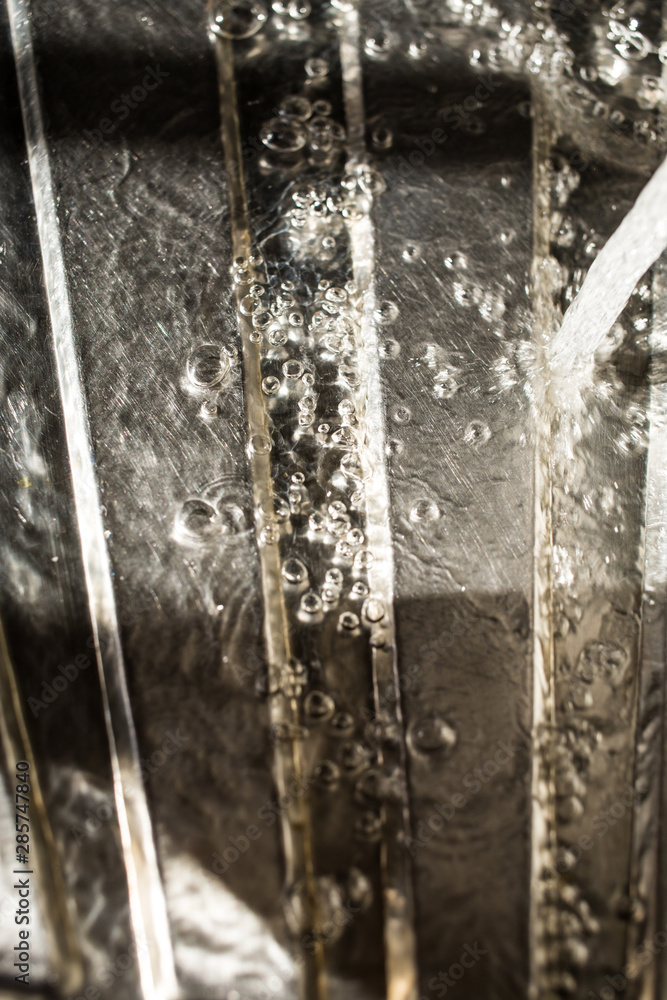 Drops of water falling on silver surface, sink in kitchen Drops of water falling on silver surface, sink in kitchen