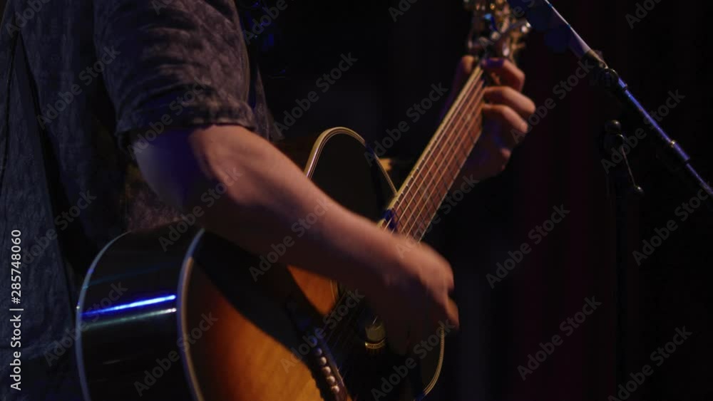 Slow motion of musician playing acoustic guitar on stage Slow motion of musician playing acoustic guitar on stage
