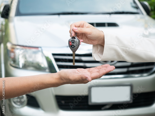 Close up of handing over the keys for a car to a young businessman.  car driving, travelling trip, vehicle automobile rent, safety insurance concept