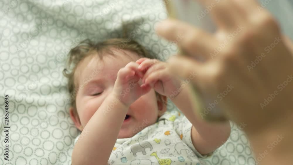 Slow motion of baby looking up at cell phone and smiling Slow motion of baby looking up at cell phone and smiling
