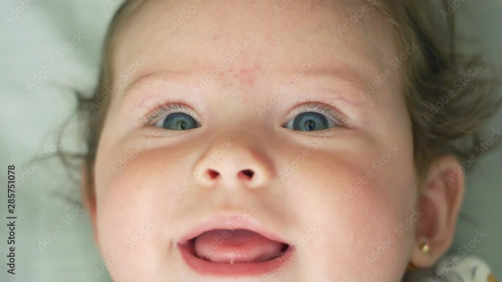 Close-up of beautiful baby smiling at camera in slow motion Close-up of beautiful baby smiling at camera in slow motion